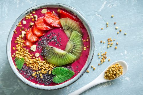 Acai smoothie bowl with chia seeds, fruits, berries (strawberries) and bee pollen 